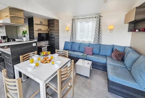 un salon avec une table et un canapé bleu dans l'établissement Nomadys, à Litteau