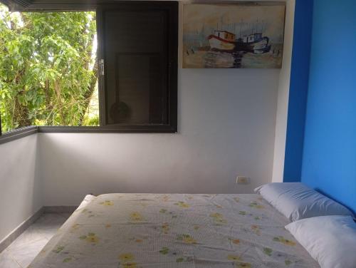 un dormitorio con una cama y una ventana en Suítes da Malu, en São Sebastião
