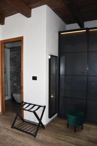 a room with a green ottoman and a black refrigerator at Il Vecchio Casale B&B in Sedini