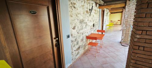 a hallway with orange chairs and a wooden door at Palazzo Cafarelli in Laureana Cilento