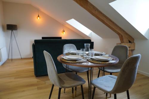 une salle à manger avec une table et des chaises dans l'établissement Les Combles d'Éliot - Charme sur la vallée, à Chambon-sur-Lac