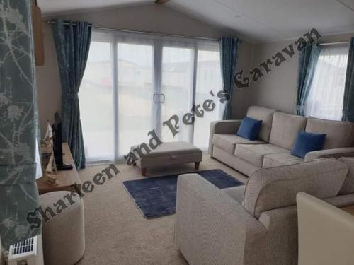 a living room with couches and a couch and a window at Sharleen&Peters Caravan in Scratby