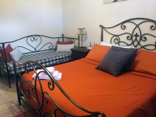 a bedroom with an orange bed and a bench at Bed and Breakfast Bike in Bagnoregio