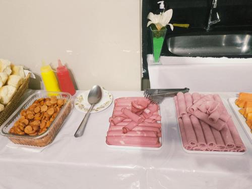 a table with two trays of hot dogs and other food at Solar Hostel Centro in Rio de Janeiro