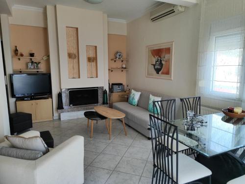 un soggiorno con un divano e un tavolo di Aristotelis Apartments a Limenaria