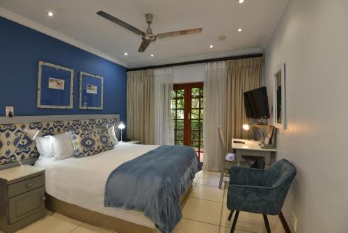 Un dormitorio con una cama tamaño king y una silla. en Rivonia Premier Lodge, en Johannesburgo