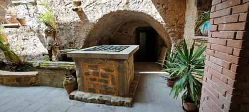 a brick building with a stone archway with potted plants at Palazzo Cafarelli in Laureana Cilento