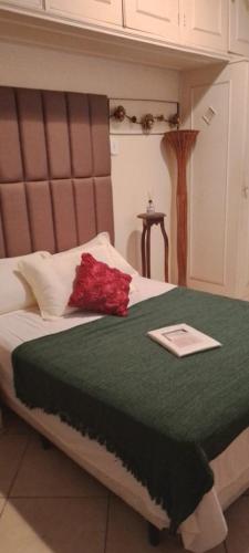 a bed with a red flower on top of it at Apê da Terezinha in Rio de Janeiro