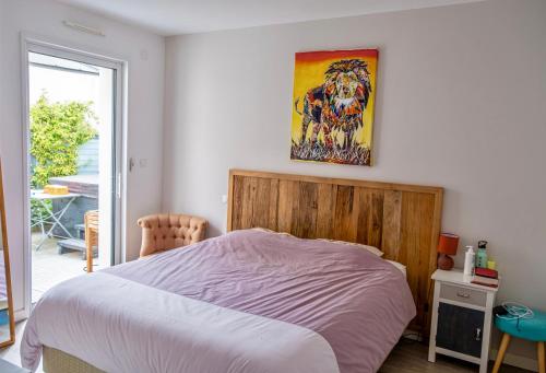 une chambre avec un lit et un tableau au mur dans l'établissement Maison de famille à 14min à pied de la mer, à Pornic