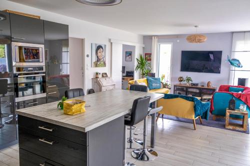 une cuisine et un salon avec une table et des chaises dans l'établissement Maison de famille à 14min à pied de la mer, à Pornic