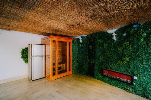 a room with a refrigerator and a green wall at Panorama Villa House Sarajevo- Jacuzzi, Bazen & Pogled na Grad 1 in Sarajevo