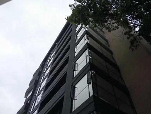 a tall building with glass windows on the side of it at Hotel Rulay Medellin in Medellín