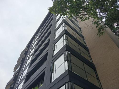 a tall building with glass windows on the side of it at Hotel Rulay Medellin in Medellín