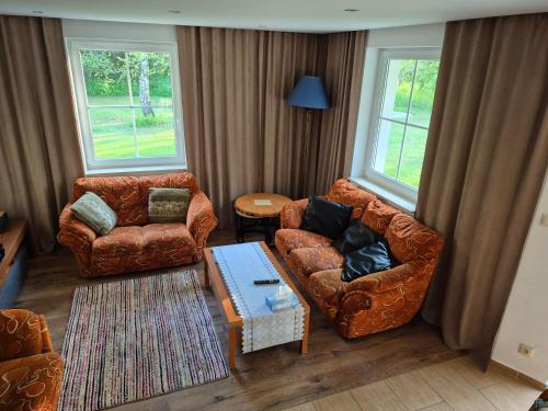 a living room with two couches and a coffee table at Domek na Mazurach-Piasutno in Piasutno