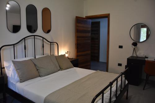a bedroom with a bed with four mirrors on the wall at Il Vecchio Casale B&B in Sedini