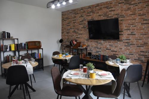a dining room with two tables and a brick wall at Il Vecchio Casale B&B in Sedini