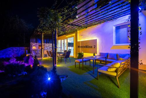 a patio with a table and chairs at night at Panorama Villa House Sarajevo- Jacuzzi, Bazen & Pogled na Grad 2 in Petruše