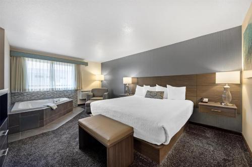 a hotel room with a bed and a bath tub at Best Western Plus City Center in Spokane