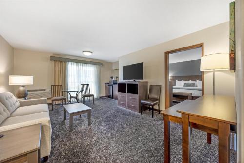 a living room with a couch and a room with a bed at Best Western Plus City Center in Spokane