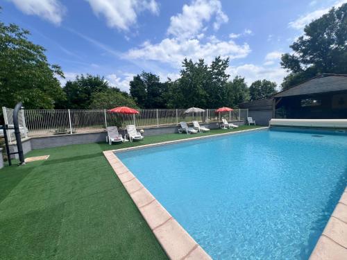 une piscine avec chaises et parasols dans une cour dans l'établissement Les Caselas, à Gramat