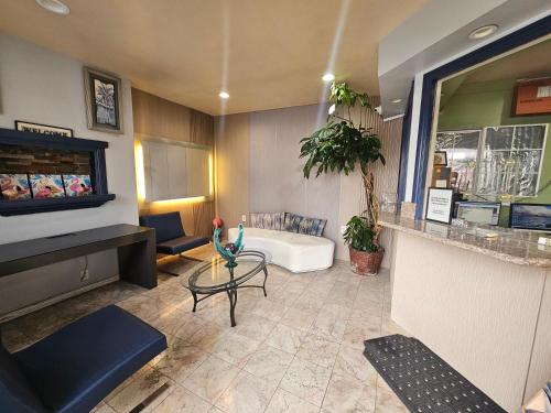 a hotel room with a waiting area with a table at Flamingo Inn in Rosemead