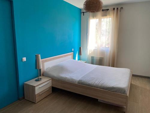- une chambre bleue avec un lit et un mur bleu dans l'établissement Quiet house in provence, à Lauris