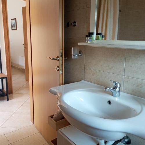 a bathroom with a white sink and a mirror at Ilios in Pogoniá