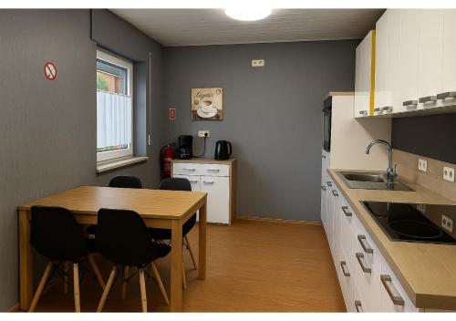 a kitchen with a table and chairs in a room at Erft Apartment in Kerpen