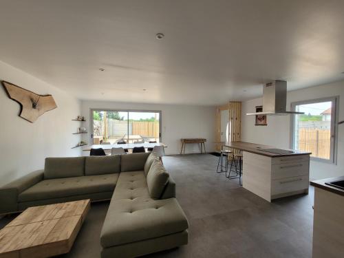 a living room and kitchen with a couch and a table at Les écuries in Secondigny