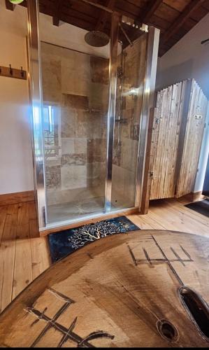 a shower in a room with a wooden floor at Nuit de Légende en Beaujolais in Lantignié-en-Beaujolais