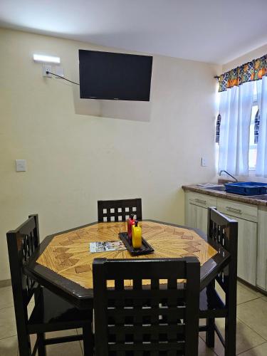 a dining room table with chairs and a television on the wall at Sensity home Departamento 2 Hogareño y confortable in Tehuacán