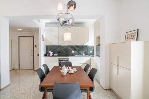 a kitchen and dining room with a wooden table and chairs at Central Cernobbio - Modern apartment in Cernobbio