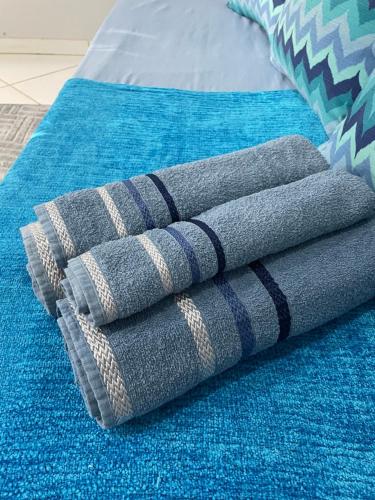 a pile of towels sitting on top of a bed at Kitnet aconchegante in Rio das Ostras
