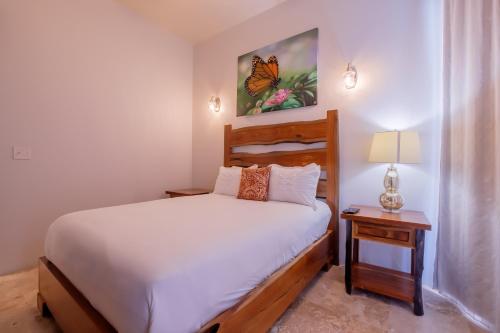a bedroom with a bed and a butterfly painting on the wall at Diamante Beachfront Suites in San Pedro
