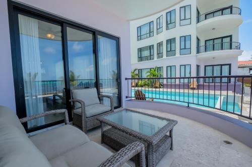 a balcony with a table and chairs and a building at Diamante Beachfront Suites in San Pedro