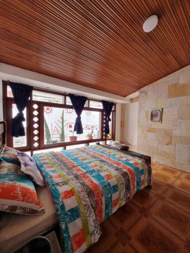 a bedroom with a bed and a large window at Hostal Casalé Usaquén Embajada de Mexico in Bogotá