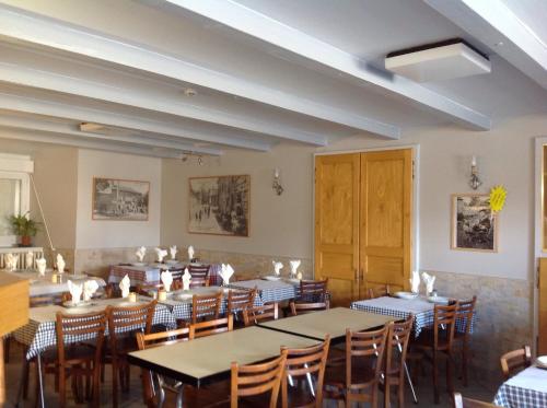 a restaurant with tables and chairs in a room at Auberge du Meygal in Champclause