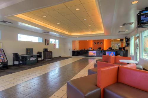 a waiting room with couches and televisions in a building at Tropicana Stays By Townhouse in Las Vegas