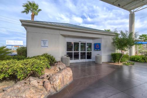 a white building with a palm tree in front of it at Tropicana Stays By Townhouse in Las Vegas