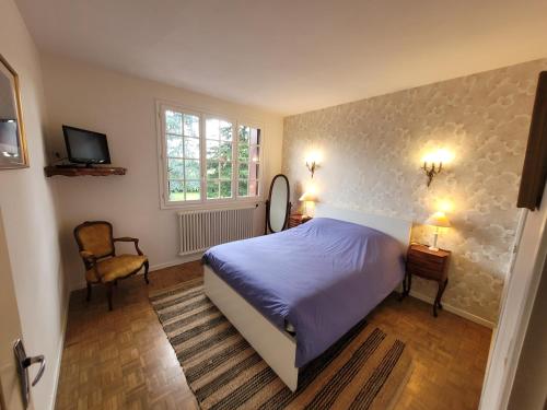 a bedroom with a bed and a window and a chair at Villa Clair Soleil au cœur de la Toscane Occitane in Lisle-sur-Tarn