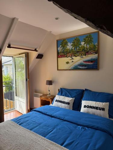 - une chambre avec un lit bleu et une vue sur la plage dans l'établissement Pti Case, à Dinard