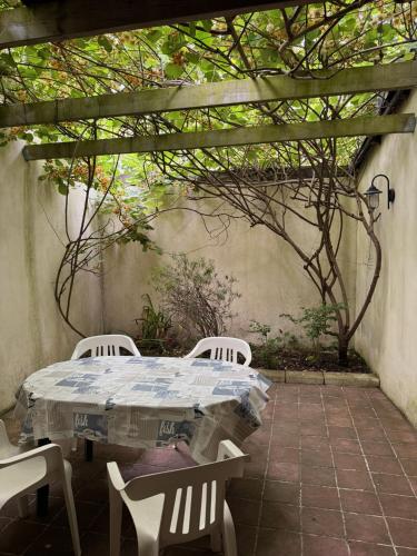 une table et des chaises assises sur une terrasse dans l'établissement Pti Case, à Dinard