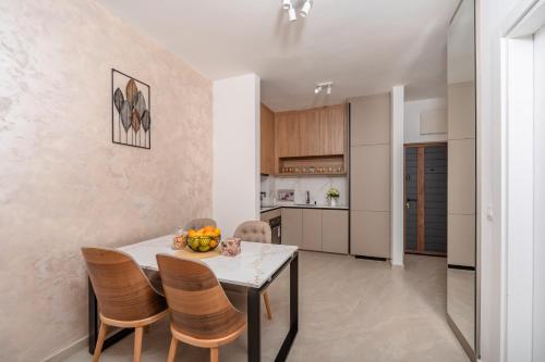 a kitchen and dining room with a table and chairs at Wave Apartments - Dobra Voda in Bar
