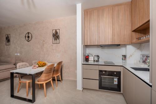a kitchen and living room with a table and chairs at Wave Apartments - Dobra Voda in Bar