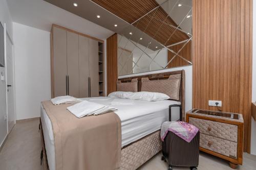 a bedroom with a large bed and a suitcase at Wave Apartments - Dobra Voda in Bar