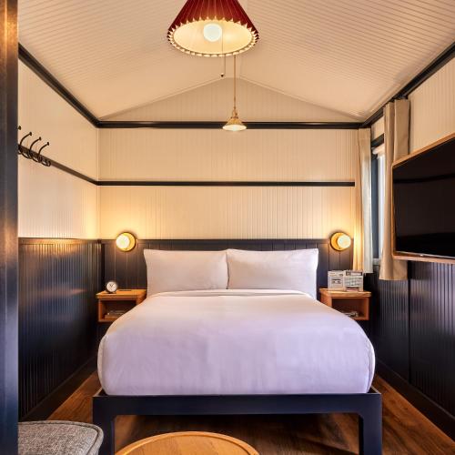 a bedroom with a large bed and a tv at High Country Motor Lodge - Near NAU and Downtown in Flagstaff