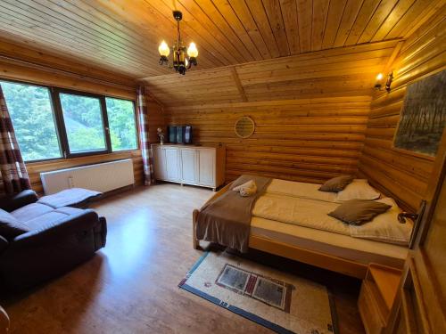 a bedroom with a bed in a wooden cabin at Lucky Rönk vendégház in Vîlcele