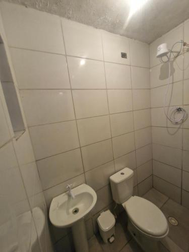 a white bathroom with a toilet and a sink at aurora dois in Guarulhos
