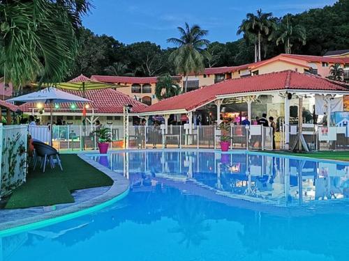 a large swimming pool in front of a resort at Studio Les Hauts de Caritan in Sainte-Anne