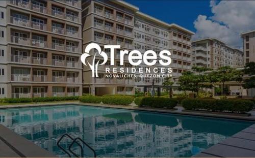 マニラにあるCondo in Greater Lagro Trees Residences 2の大きなアパートメントで、目の前にプールがあります。